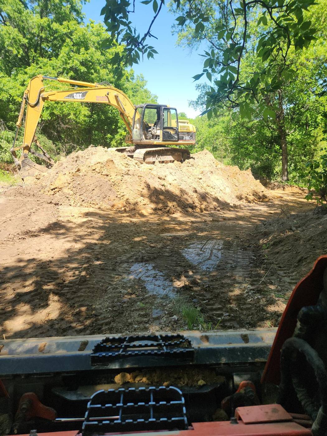 Excavator working on top of a spoil pile